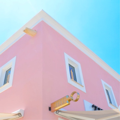 Corner view of a pink house and blue sky in the background
